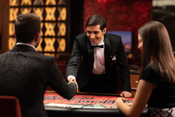 সবুজ বিলাসবহুল গাউন পরা এক নারী অলংকৃত রুলেট চাকার পাশে—যা PARIPULSEE–এর উচ্চমানের ক্যাসিনো পরিবেশকে প্রকাশ করে।